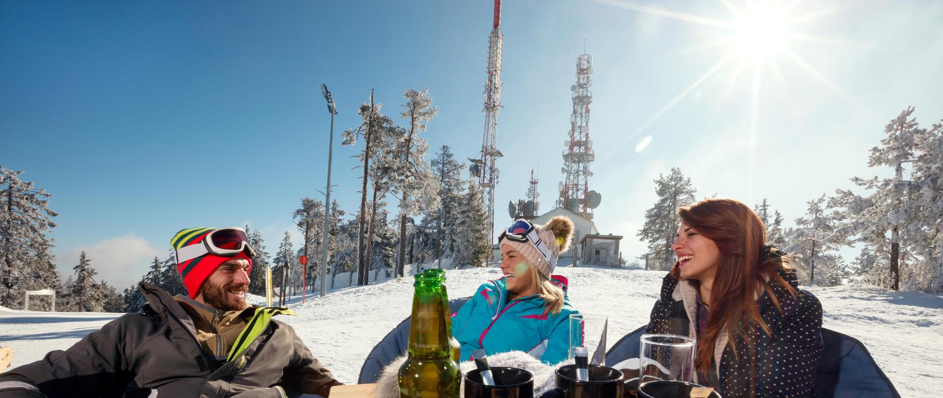 Friends laughing and enjoying in drink at ski resort together