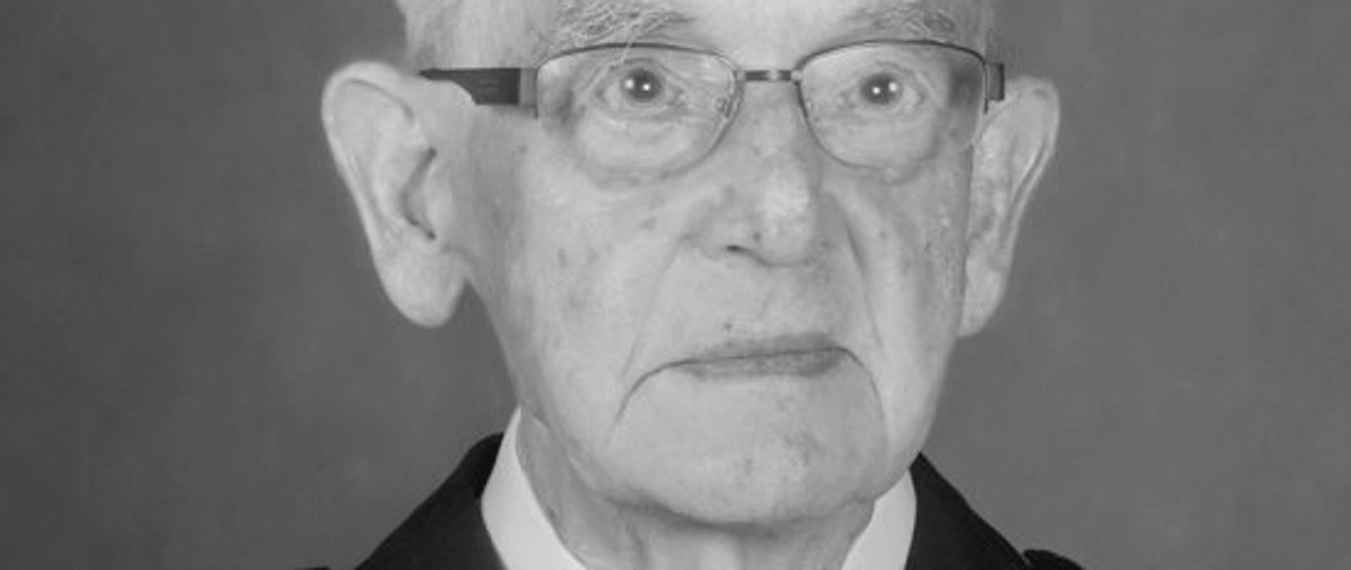 czarno-białe zdjęcie strażaka w mundurze w białej koszuli z krawatem
