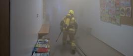 Strażak przeszukujący pomieszczenia przedszkola.