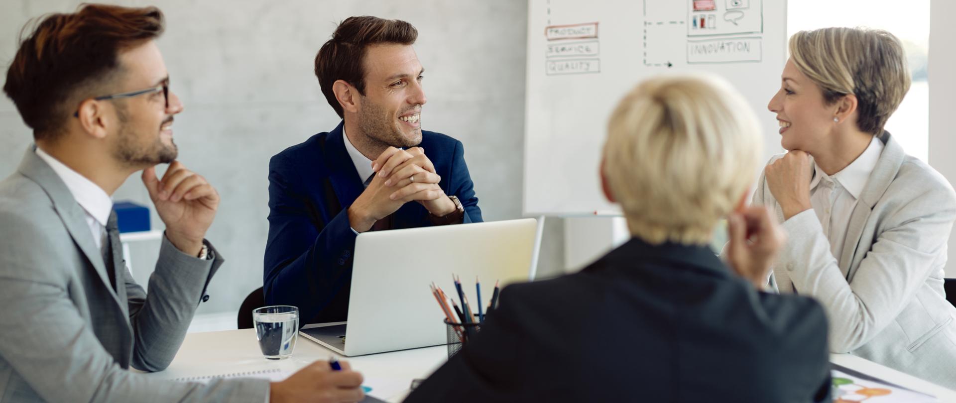 Grupa kolegów rozmawiających podczas spotkania biznesowego w biurze