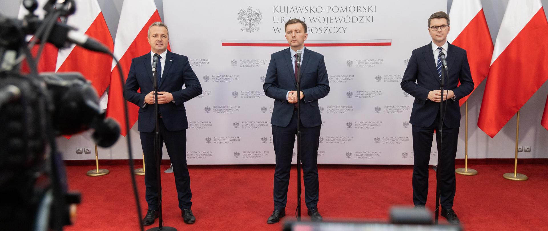 Minister-członek Rady Ministrów Łukasz Schreiber, sekretarz stanu w KPRM, rzecznik prasowy rządu Piotr Müller oraz Wojewoda Kujawsko-Pomorski Mikołaj Bogdanowicz na konferencji Polski Ład dla samorządów