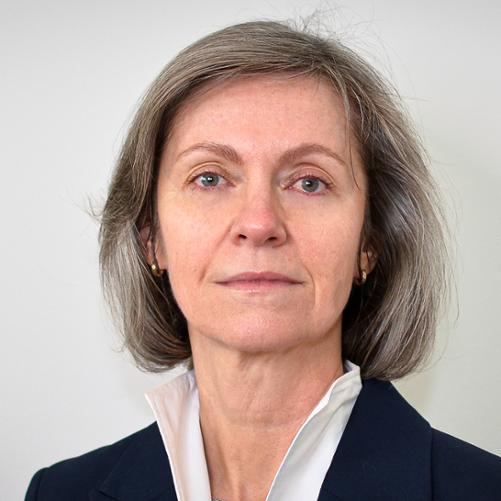 Kobieta w ciemnej marynarce, białej bluzce i włosami do ramion.