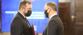 Prezydent Andrzej Duda gratuluje ministrowi Grzegorzowi Pudzie
