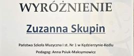 Na plakacie w jasnej, białej kolorystyce przedstawiono dyplom z niebieskimi i czarnymi elementami graficznymi, w tym logo z kluczem wiolinowym i stylizowaną postacią dziecka oraz falującym motywem muzycznym u dołu.
Centralnie dużą czcionką zapisano „WYRÓŻNIENIE”, poniżej imię i nazwisko „Zuzanna Skupin”, a wyżej informację o VI Ogólnopolskim Konkursie „Co Młodym w Duszy Gra?” z datą 23–25 kwietnia 2026 roku i miejscem wydarzenia.
W dolnej części znajdują się nazwa szkoły, nazwisko pedagoga, podpisy organizatorów i jury oraz rząd logotypów patronów i sponsorów.