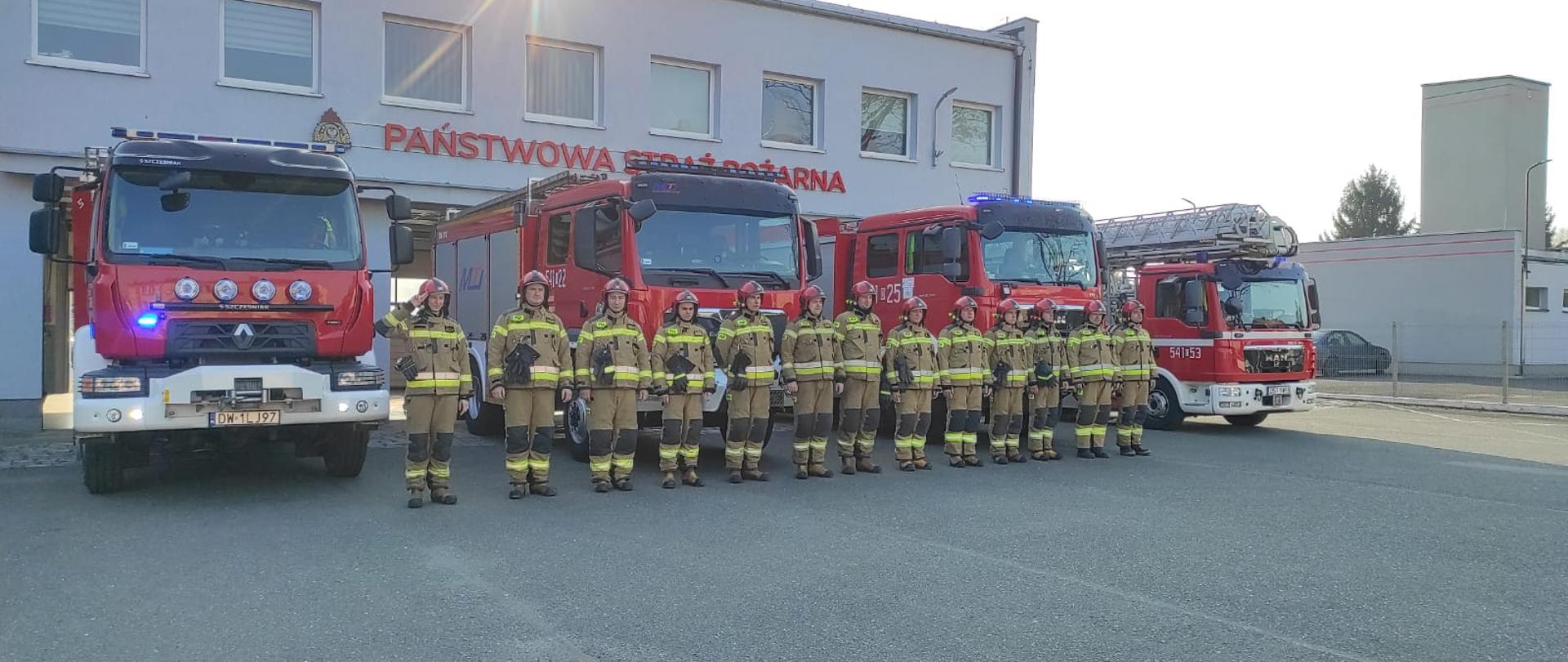 Strażacy JRG Strzelin na tle samochodów pożarniczych