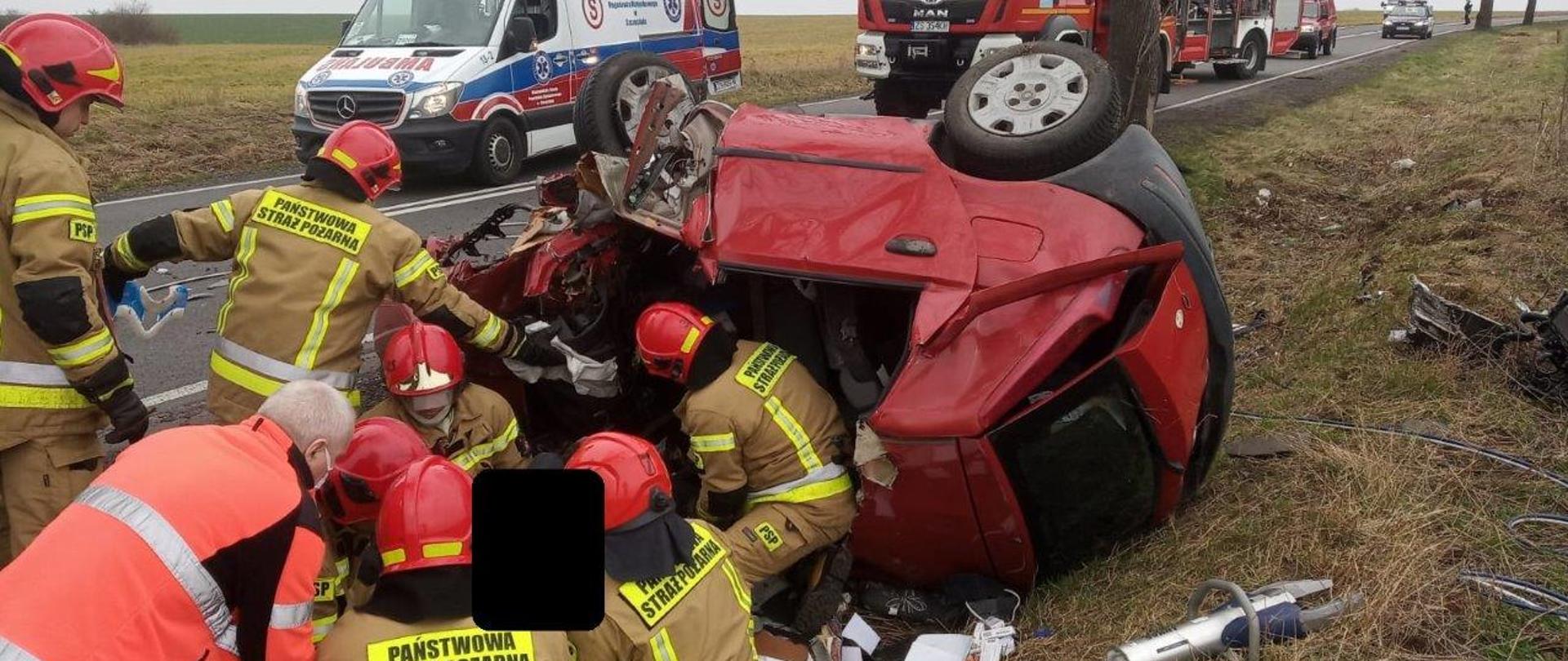 Zdjęcie przedstawia strażaków udzielających pierwszej pomocy poszkodowanym podczas działań ratowniczych