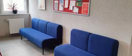 na zdjęciu dwie nowe niebieskie kanapy, nad nimi tablica informacyjna.