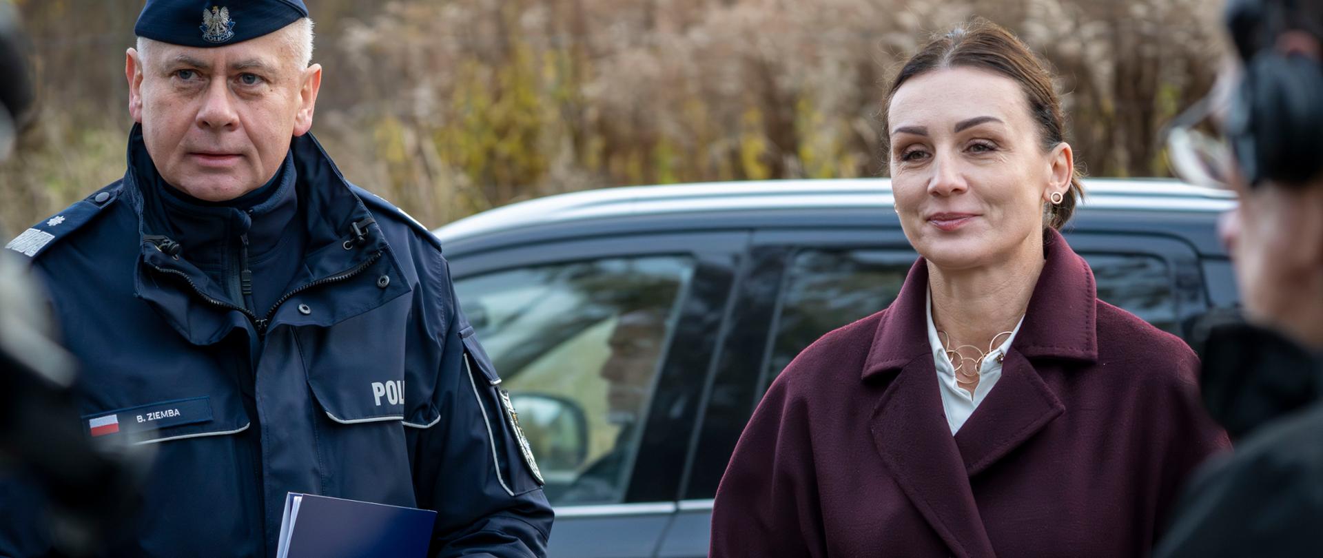 dwie osoby :policjant ni wojewoda odpowiadają na pytania dziennikarzy