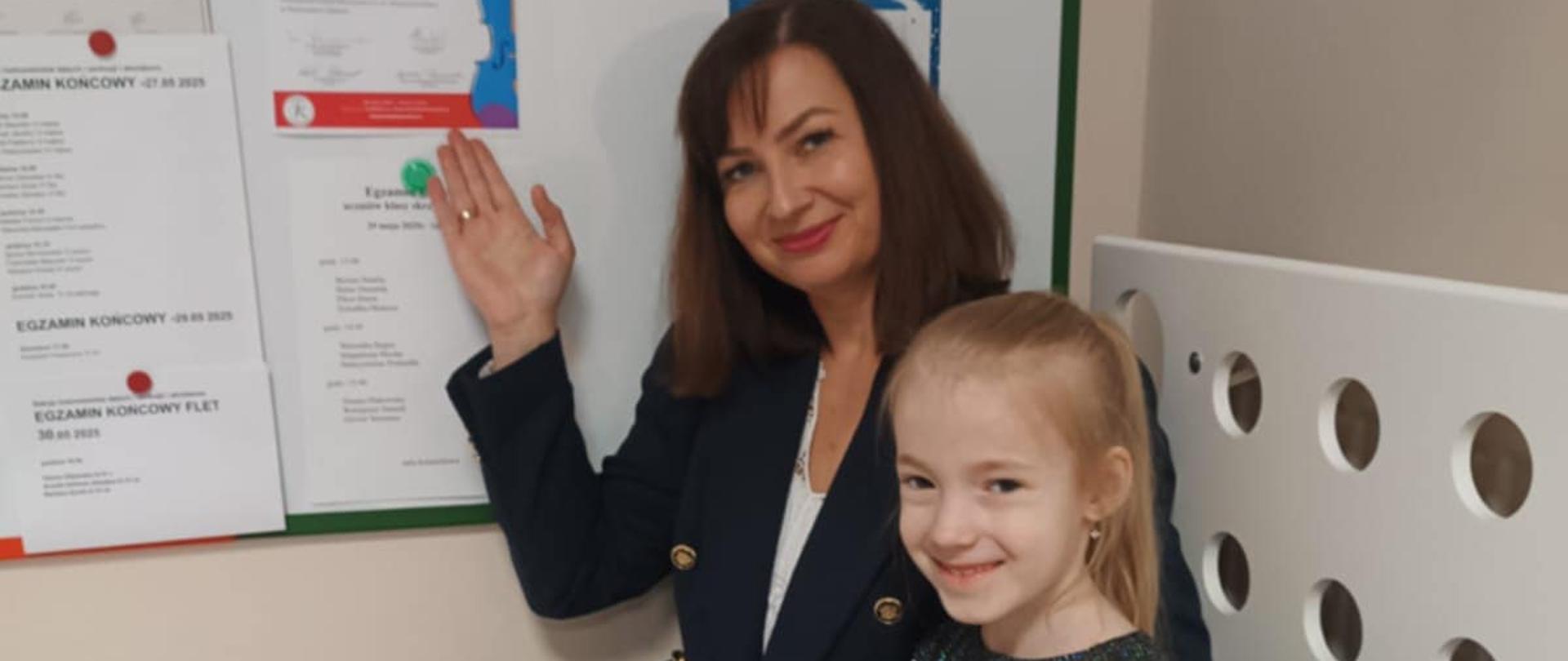 Uczennica wraz z nauczycielką prezentują dyplom