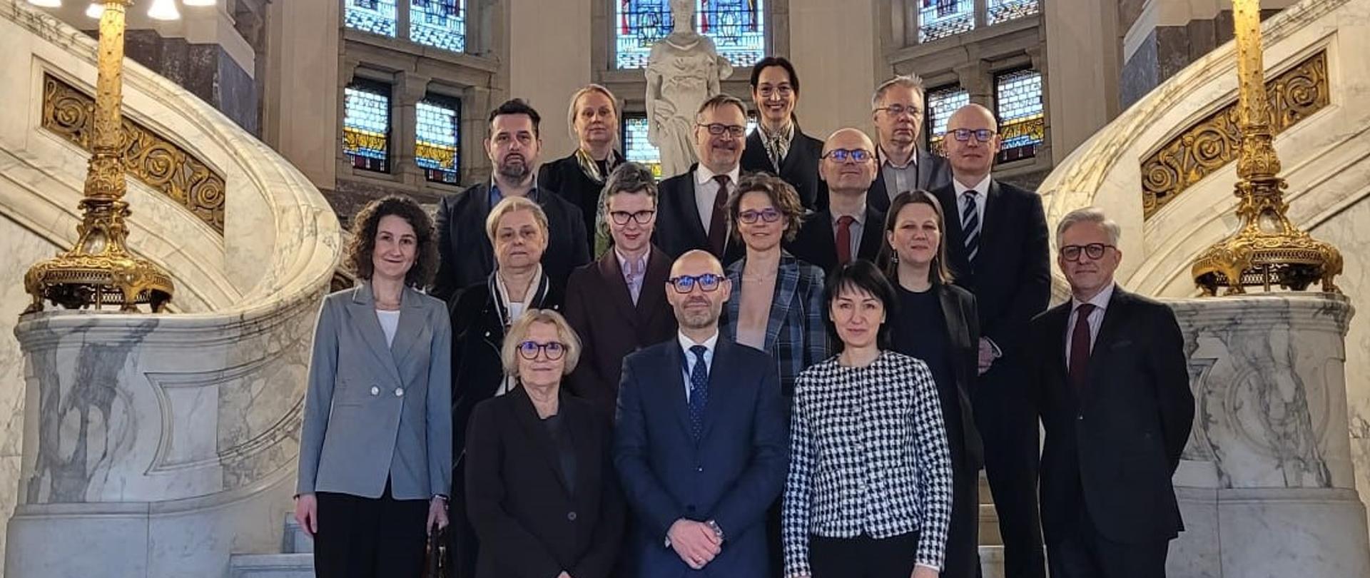 Wiceminister Mościcka-Dendys z członkami Komitetu Prawnego i ambasador RP w Królestwie Niderlandów siedzą przy stole na obradach w Hadze
