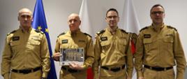 Zdjęcie przedstawia absolwenta szkolenia czyli Komendanta Powiatowego PSP w Skarżysku-Kamiennej wraz z nim do zdjęcia pozują (od lewej) Rektor Akademii Pożarniczej, Komendant Główny PSP, Prorektor Akademii Pożarniczej