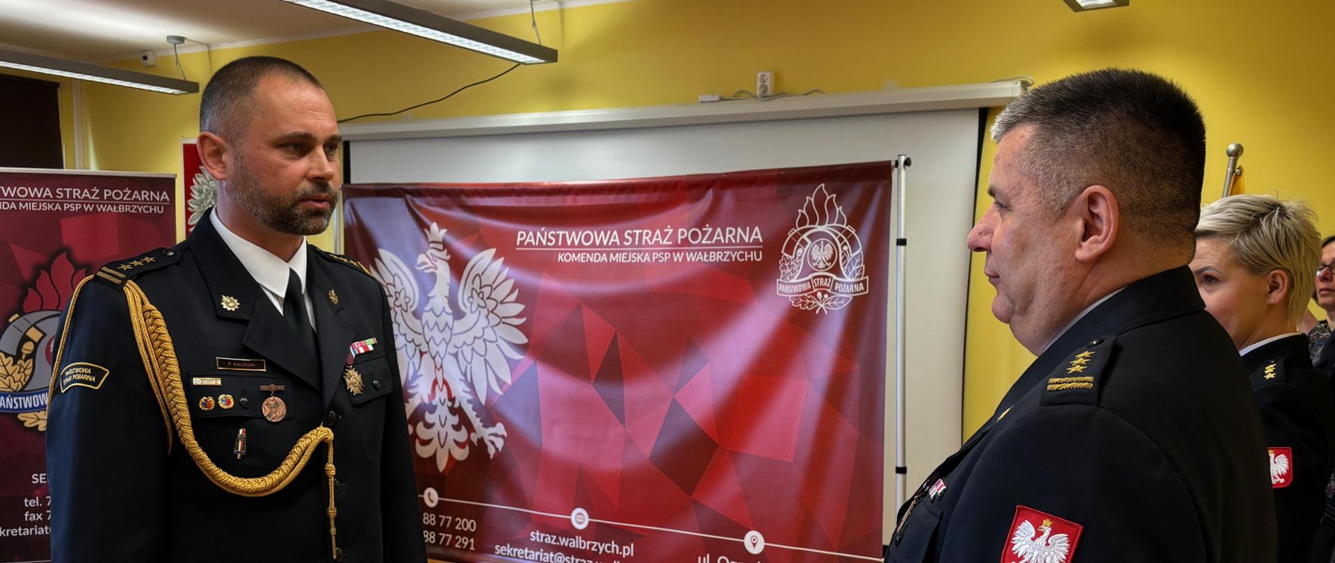 Strażacy w umundurowaniu podczas uroczystości.