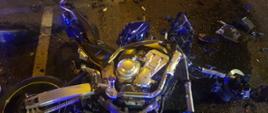 Zdjęcie wykonane w porze nocnej. Na zdjęciu widać ulicę Czarnieckiego w Radomiu. Na jezdni widać leżący uszkodzony motocykl. Dookoła niego znajdują się również porozrzucane elementy konstrukcyjne 