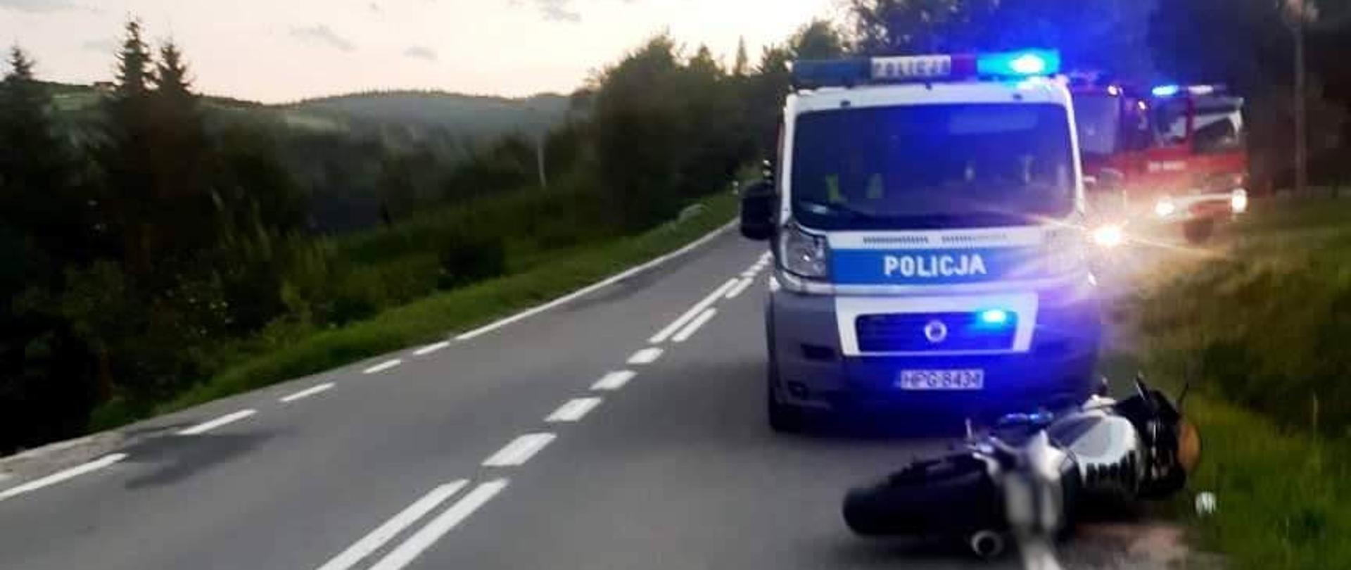 Motocykl leży na skraju drogi przez radiowozem.