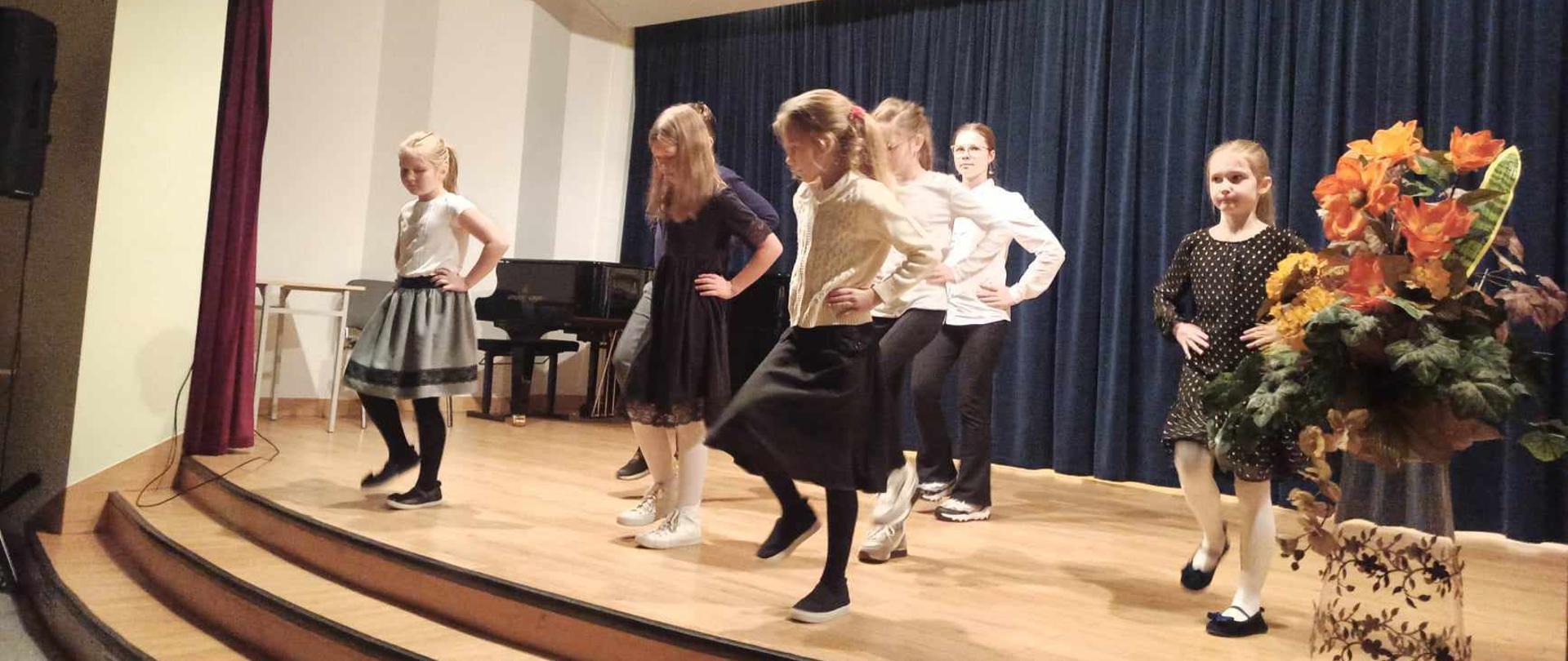 Na zdjęciu grupa dzieci tańczy na scenie.