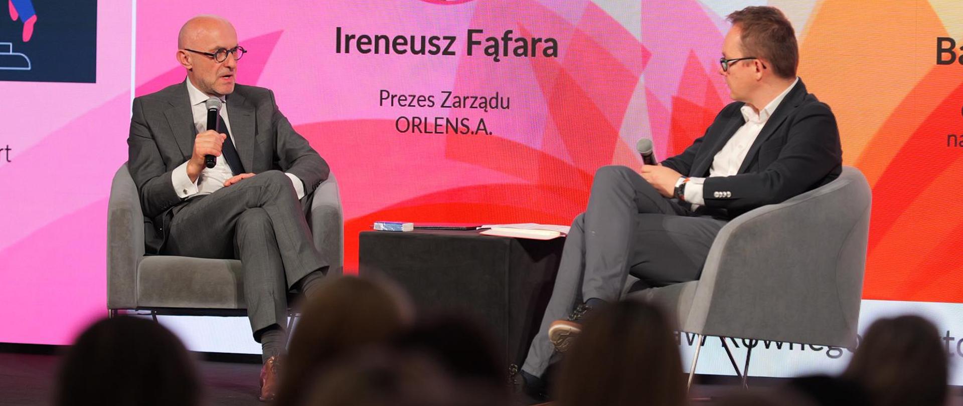 Na scenie siedzą: Ireneusz Fąfara, prezes zarządu ORLEN S.A. oraz Bartosz Pawłowski, CFA. W tle ekran. 
