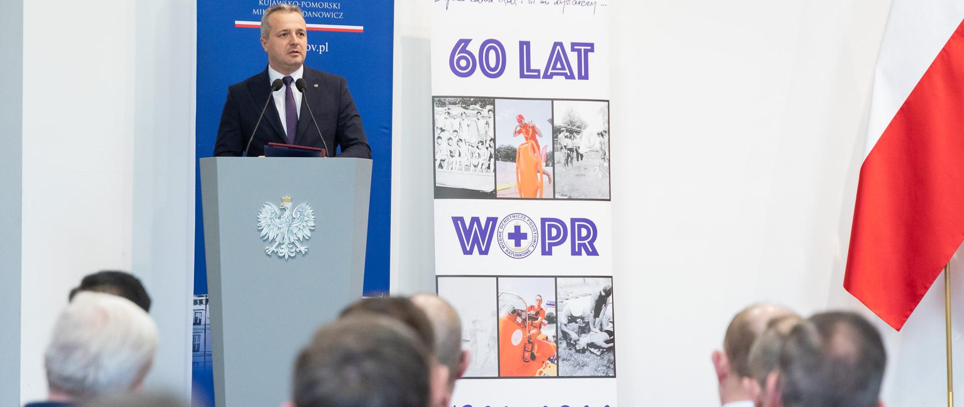 Jeden mężczyzna stojący przy mównicy i wypowiadający się