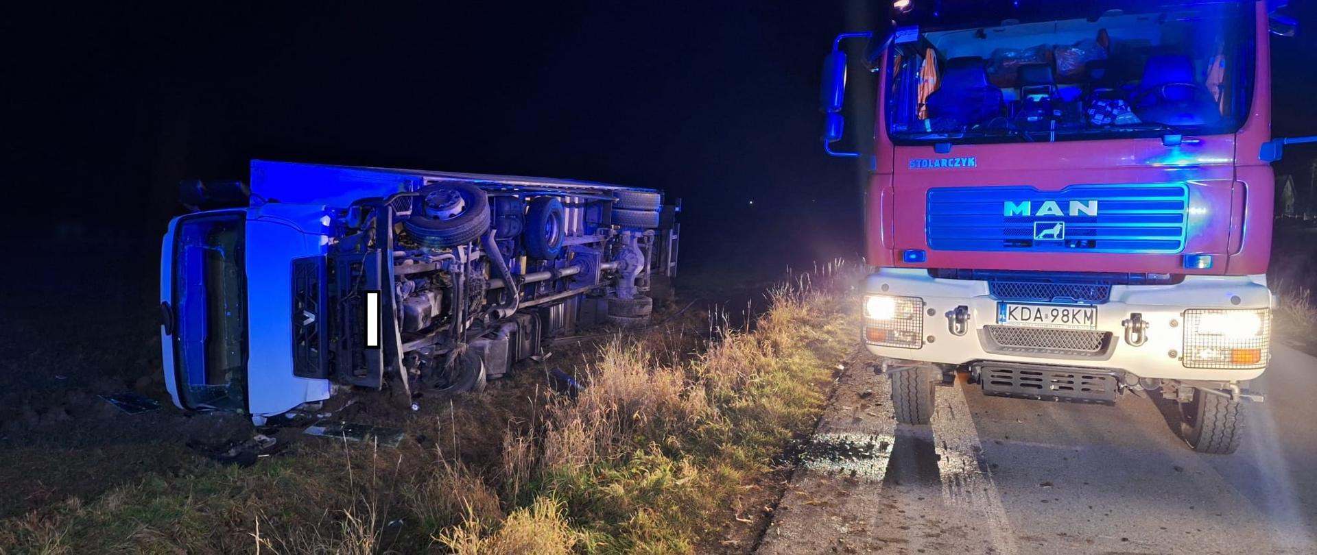 Na zdjęciu widać pojazd cieżarowy w rowie na boku i pojazd JOP.
