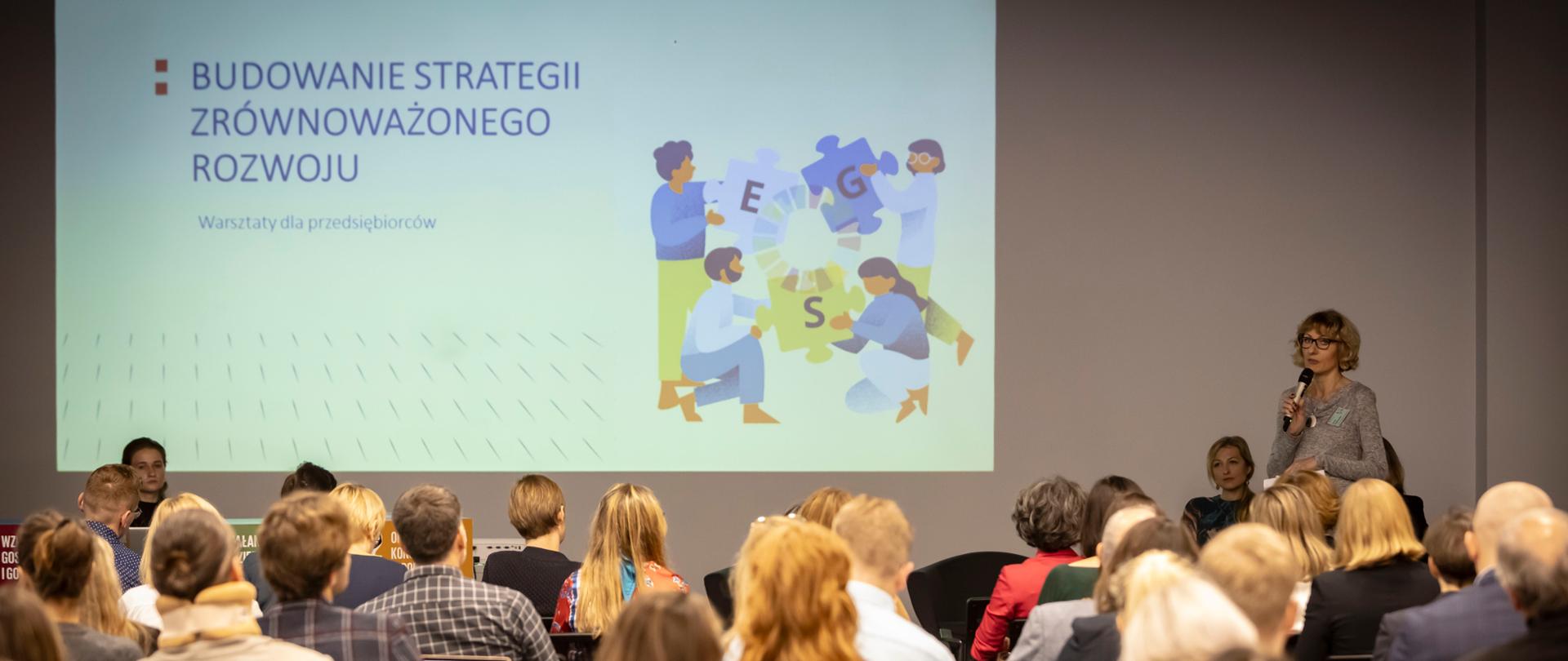 Na zdjęciu uczestnicy uczestnicy Warsztatów. Widoczna również scena, na której po prawej stronie przemawia uczestnik.