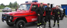 Zdjęcie przedstawia strażaków przed małym samochodem pożarniczym z podczepioną pompą wysokiej wydajności