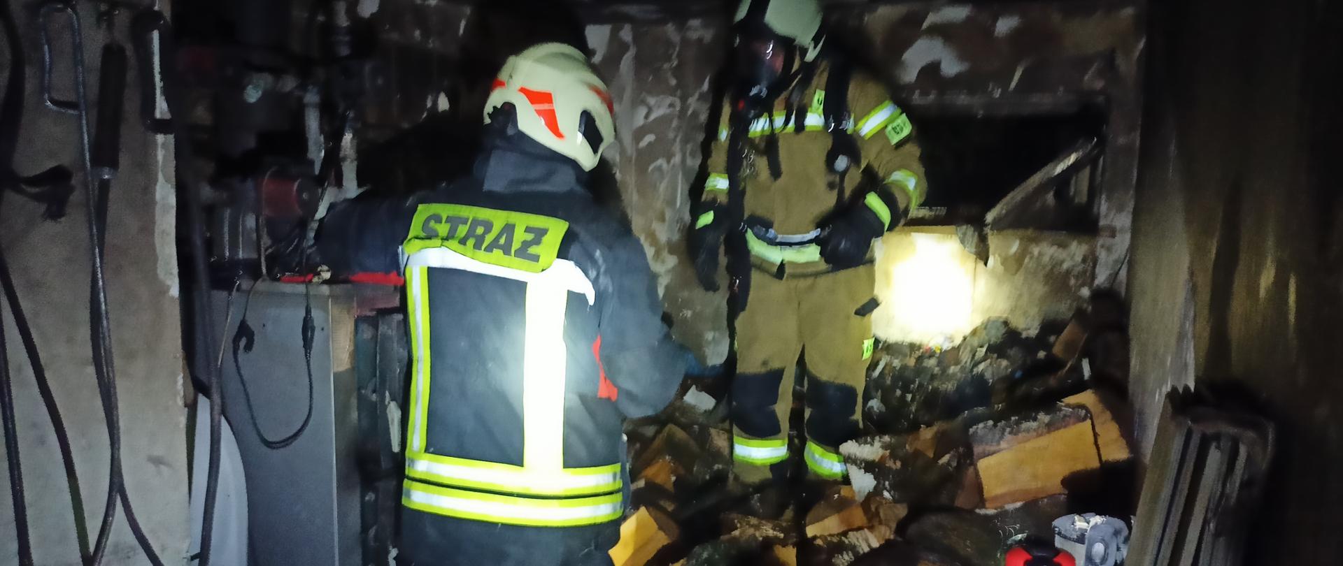 Zdjęcie przedstawia strażaków w kotłowni po pożarze 