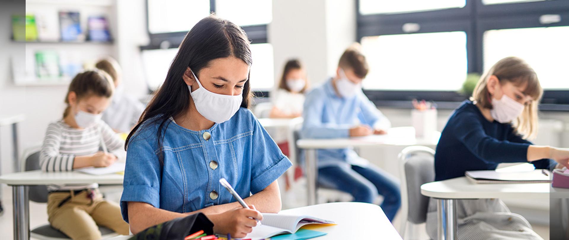 Small children with face mask back at school after covid-19 quarantine and lockdown.