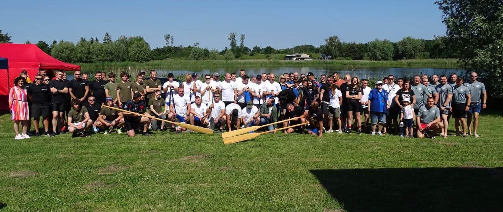 Na zdjęciu znajdują się uczestnicy II Mistrzostw Służb Mundurowych Smoczych Łodzi, zdjęcie wykonano na tle Jeziora Starogrodzkiego.