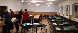 Na zdjęciu widoczne miejsca noclegowe przygotowane przez strażaków OSP między innymi łóżka polowe, stoliki, koce, rozłożone w remizie OSP w Bieczu na sali.