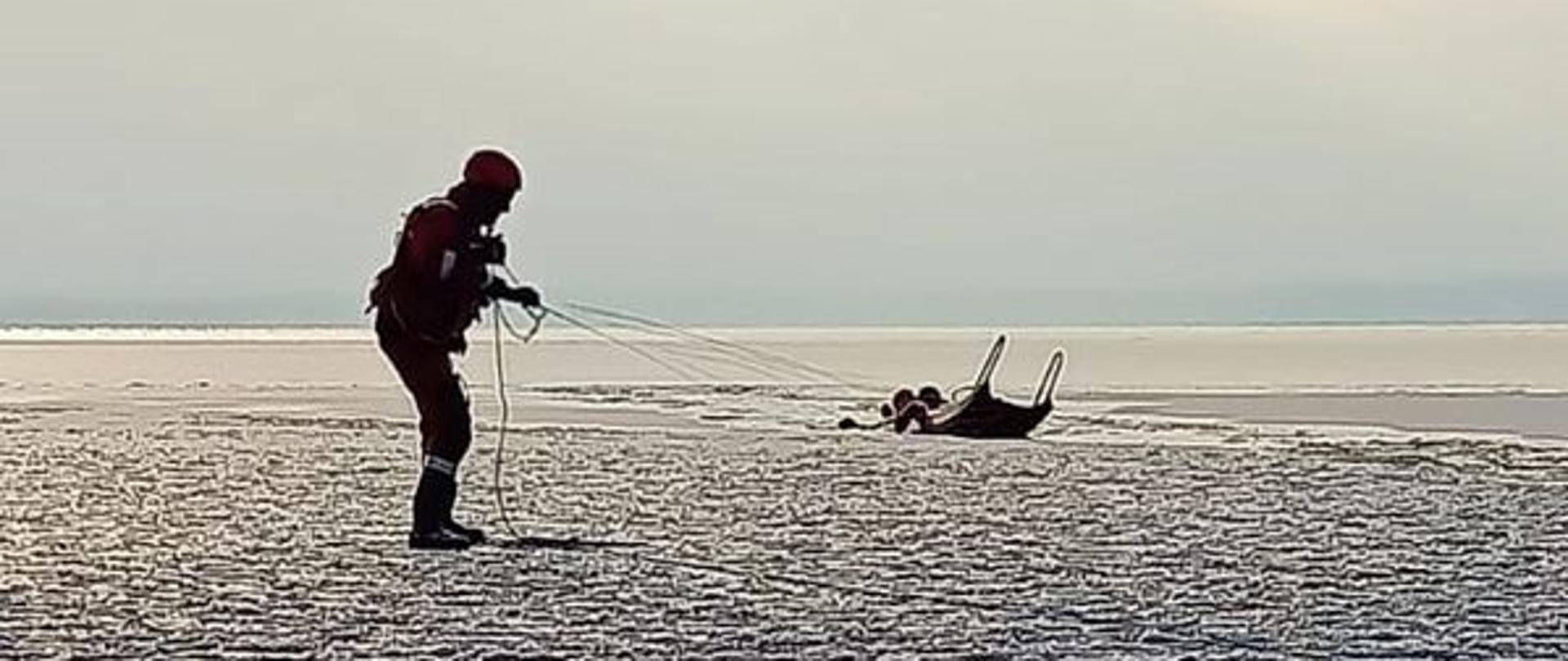 Strażacy ćwiczą podejmowanie osoby poszkodowanej na zamarzniętym jeziorze,