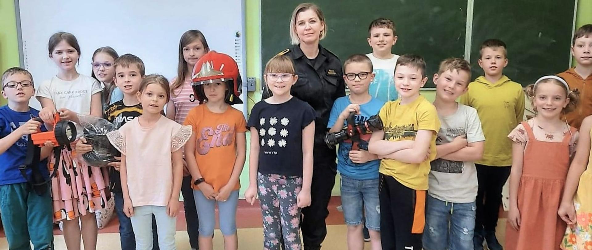 Na zdjęciu uczniowie klasy drugiej ze Szkoły Podstawowej nr 8 w Kielcach wraz z przedstawicielem Państwowej Straży Pożarnej.