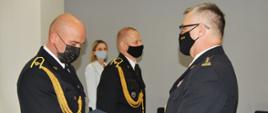 Na zdjęciu strażak obiera z rąk komendananta akt nadania stopnia służbowego. Obaj występują w umundurowaniu galowym.