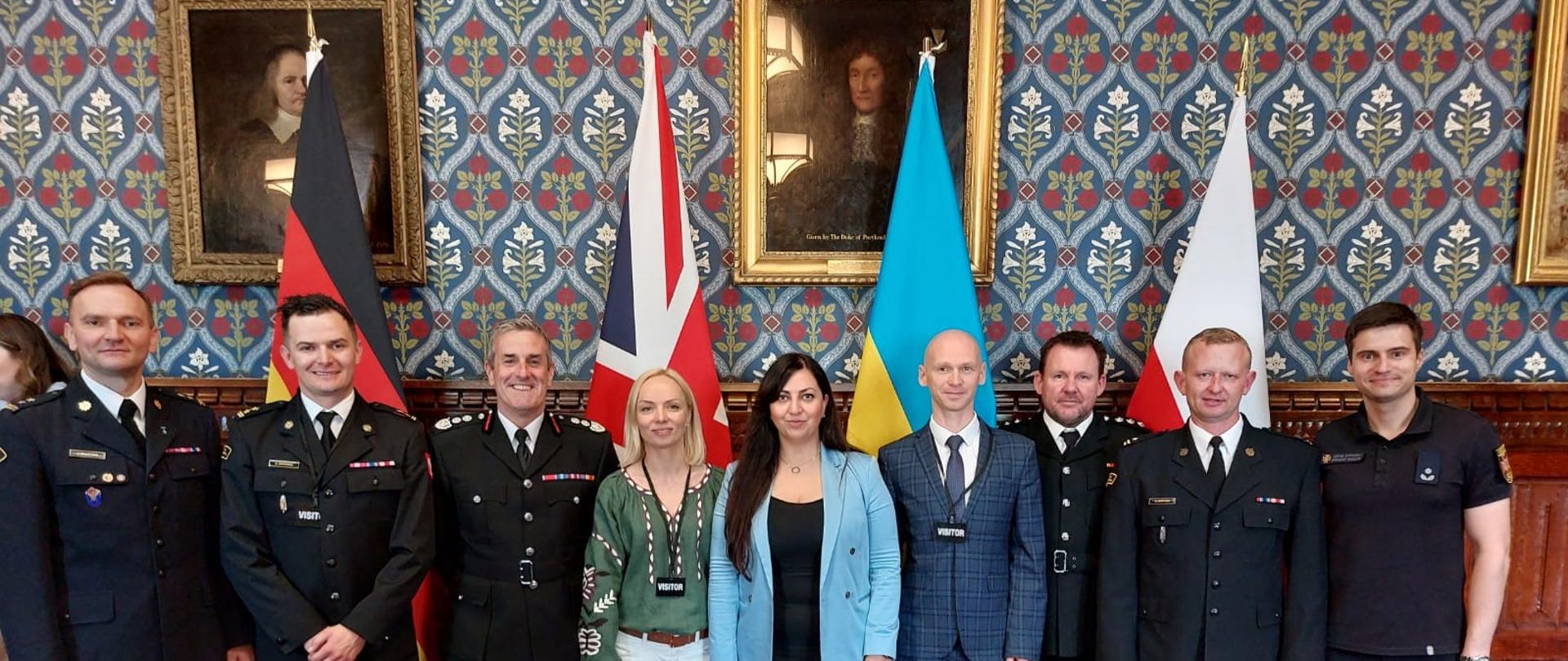 Strażacy na tle flag narodowych podczas wizyty w Londynie