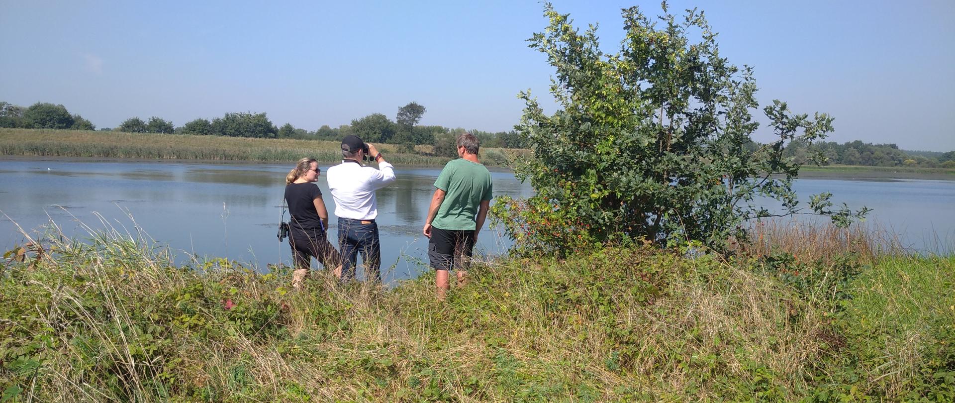 Zdjęcie osób odbierających wykonanie prac lustrujących taflę starorzecza