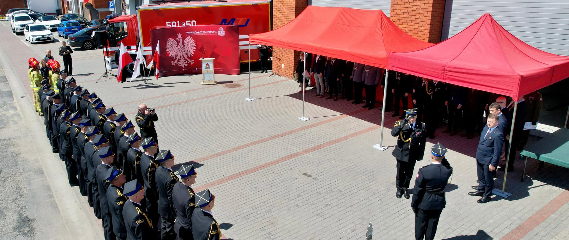 meldunek o zakończeniu uroczystości z boku pododdział strażaków przed komendą czerwone namioty