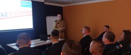 Spotkania dla dyżurnych organizowane przez OUW - zdjęcie przedstawia prezentację przygotowaną mł.kpt. Jarosława Buhla. Na zdjęciu widać również uczestników szkolenia siedzących na wprost prowadzącego.
