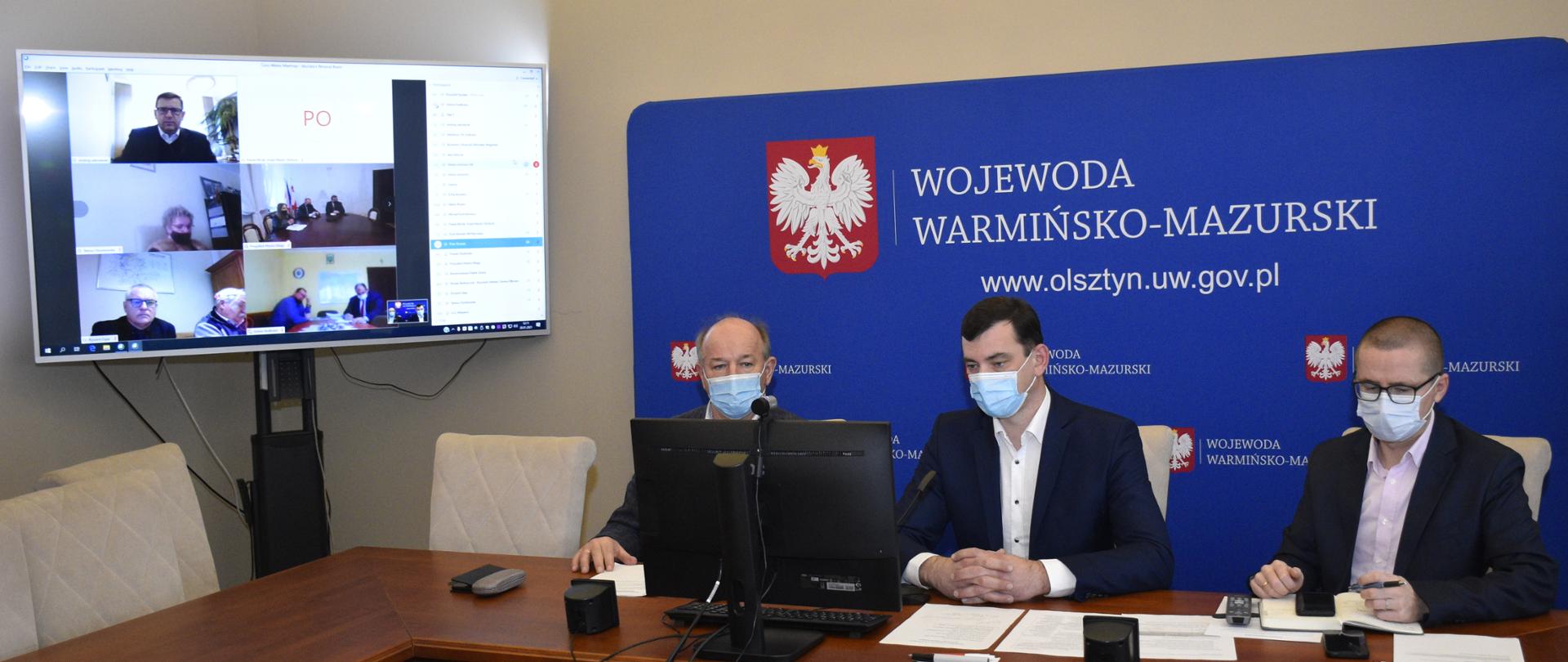 trzej ludzie siedzą na telekonferencji