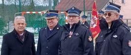 Na pierwszym planie od lewej Aleksander Mrówczyński – poseł na sejm RP, bryg. Wojciech Berent - Zastępca Pomorskiego Komendanta Wojewódzkiego PSP, odznaczony - dh Markowi Kaczmarek, dh. Marek Buza - Prezes Zarządu Oddziału Wojewódzkiego ZOSP RP woj. Pomorskiego. W tle widać poczet sztandarowy.