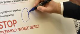 Wojewoda podpisuje manifest umieszczony na sztaludze.