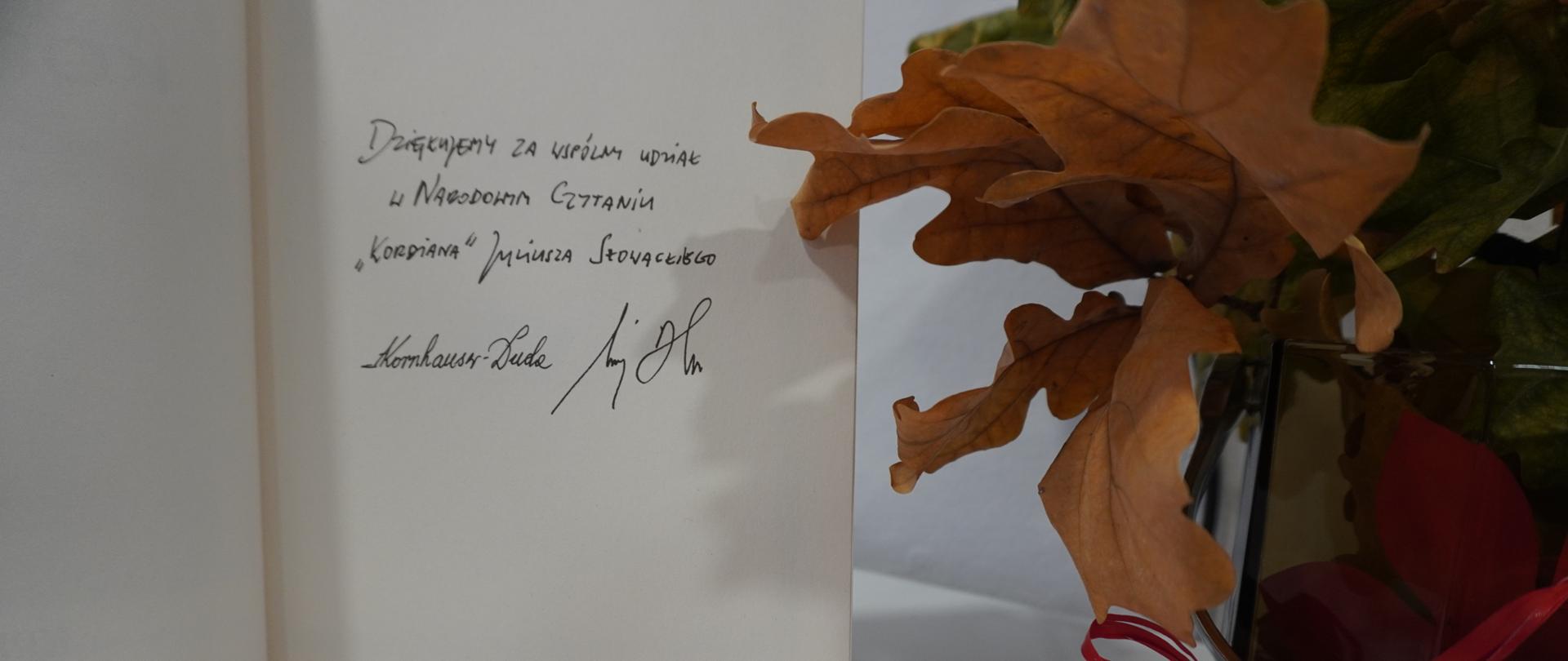 Dokument z odręcznym podziękowaniem. W tle jesienne liście.