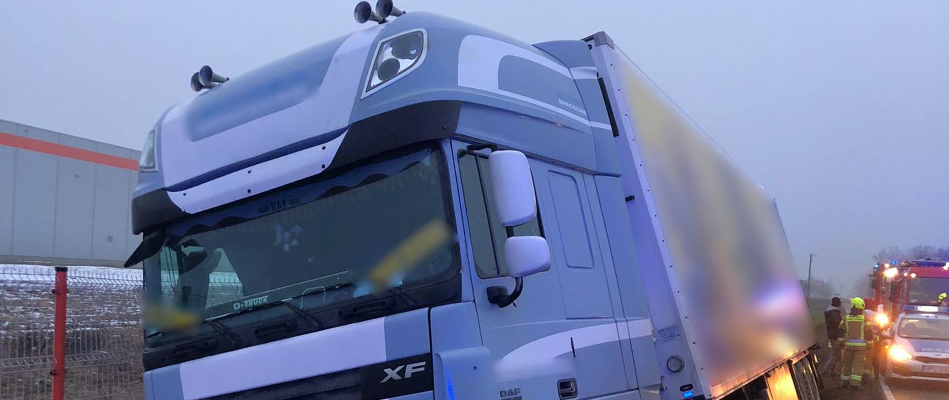 Widoczne miejsce zdarzenia ciągnik siodłowy z naczepą oraz służby zabezpieczające miejsce