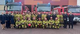 Zdjęcie grupowe z emerytem na tle samochodów pożarniczych