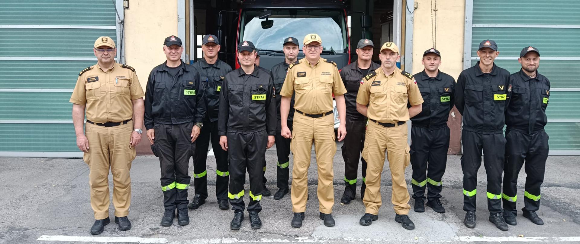 Zdjęcie od frontu. Załoga zmiany służbowej na placu apelowym JRG Wadowice. W pierwszym szeregu pierwszy od lewej Komendant Powiatowy PSP w Wadowicach, dwóch strażaków zmiany służbowej, Zastępca Komendanta Głównego PSP, Dowódca JRG Wadowice. W drugim szeregu siedmiu strażaków zmiany służbowej.