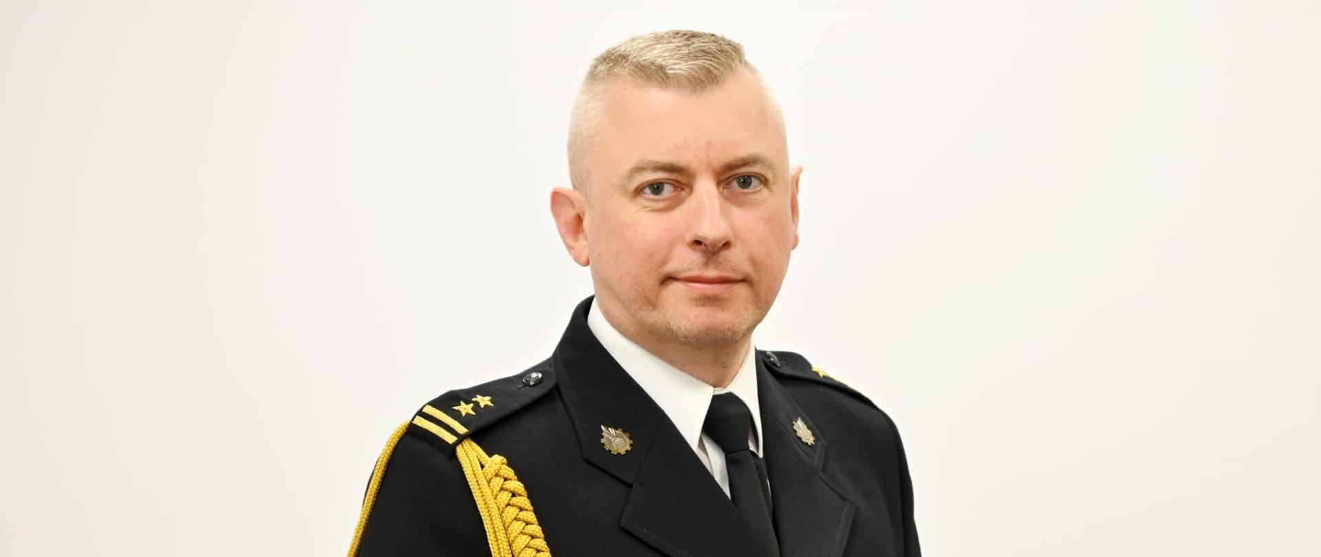 Zdjęcie portretowe w mundurze wyjściowym przedstawiające sylwetkę zastępcy komendanta miejskiego państwowej straży pożarnej w Elblągu.