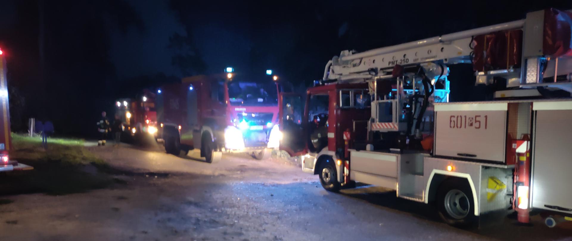 Na zdjęciu w porze nocnej stoją samochody ratowniczo - gaśnicze oraz podnośnik hydrauliczny z JRG Śrem 