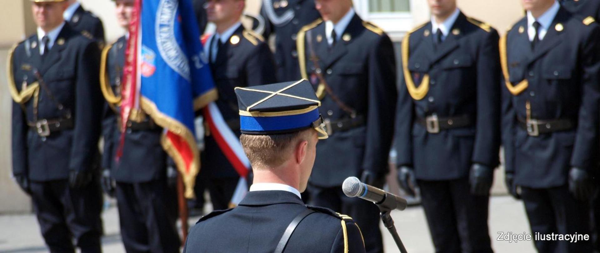 Na zdjęciu stoją strażacy z kompani honorowej w mundurach wyjściowych. Zdjęcie zrobione podczas uroczystości