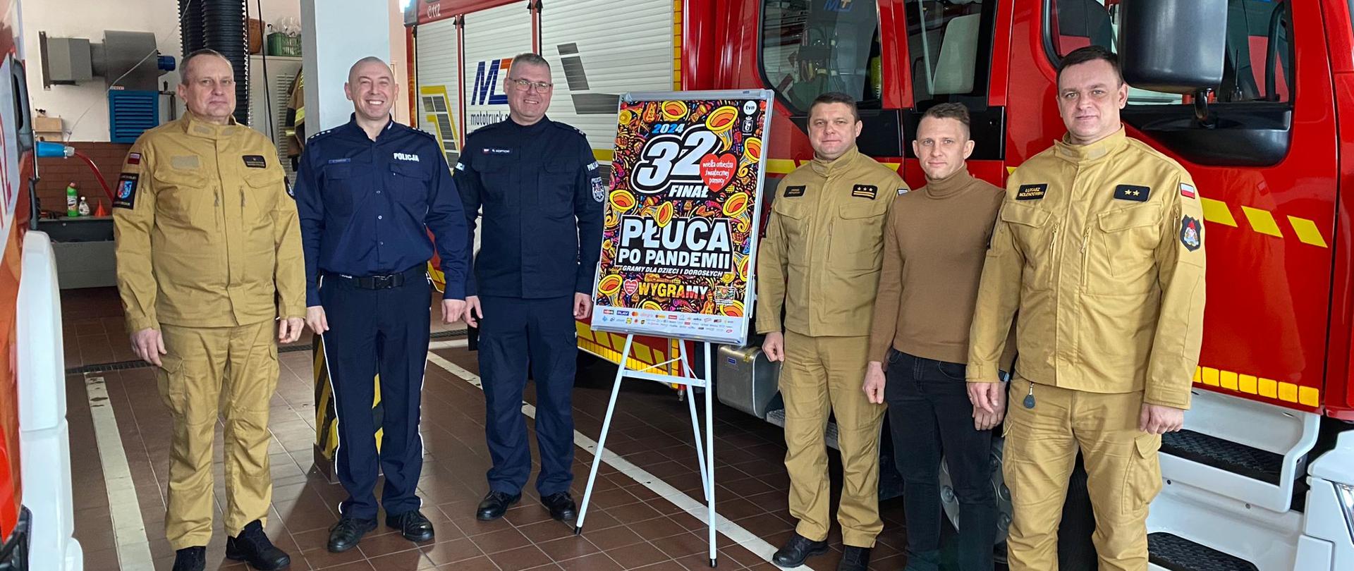 Zdjęcie grupowe z funkcjonariuszami w garażu Komendy