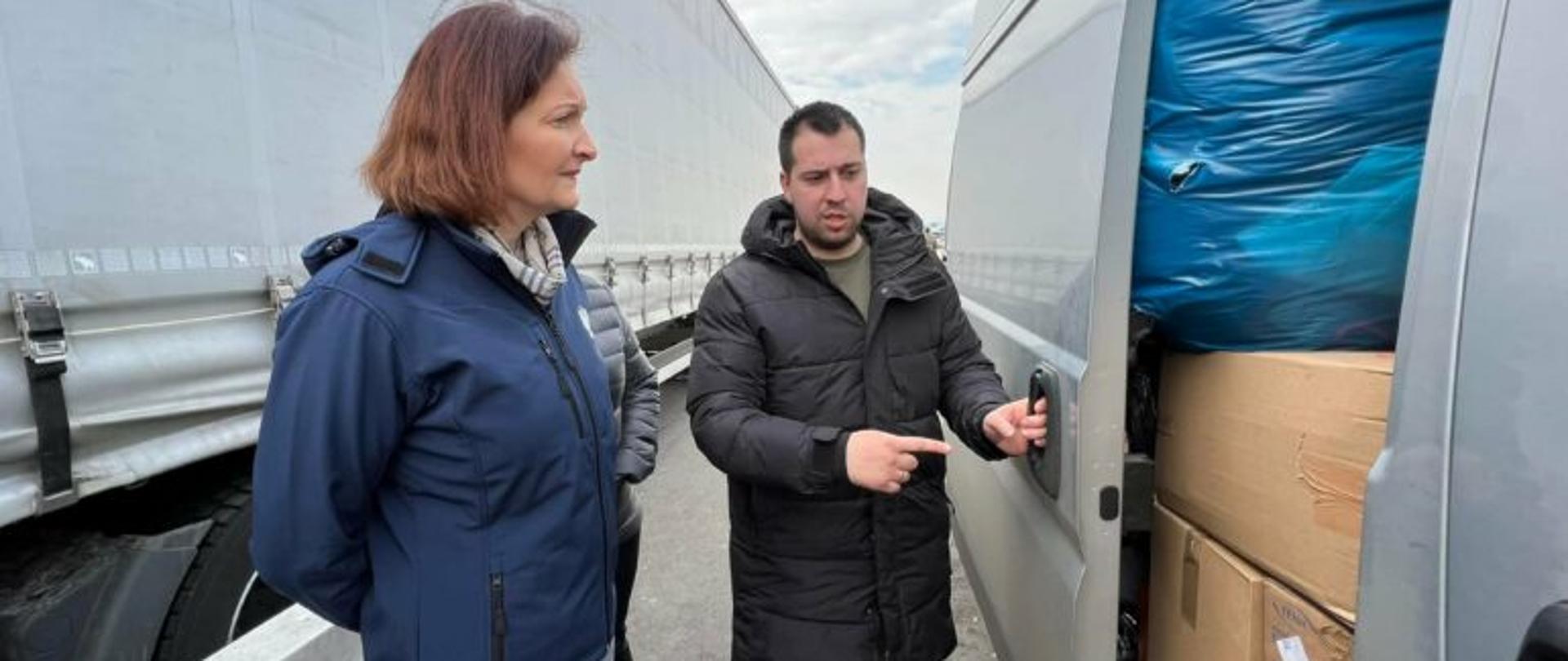 Wojewoda Ewa Leniart stoi przy busie z pomocą humanitarną. 