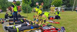 Ćwiczenia z zakresu ratownictwa technicznego. Zdjęcie przedstawia strażaków PSP oraz OSP oraz Policjantów podczas udzielania pierwszej pomocy osobom poszkodowanym podczas ćwiczeń.