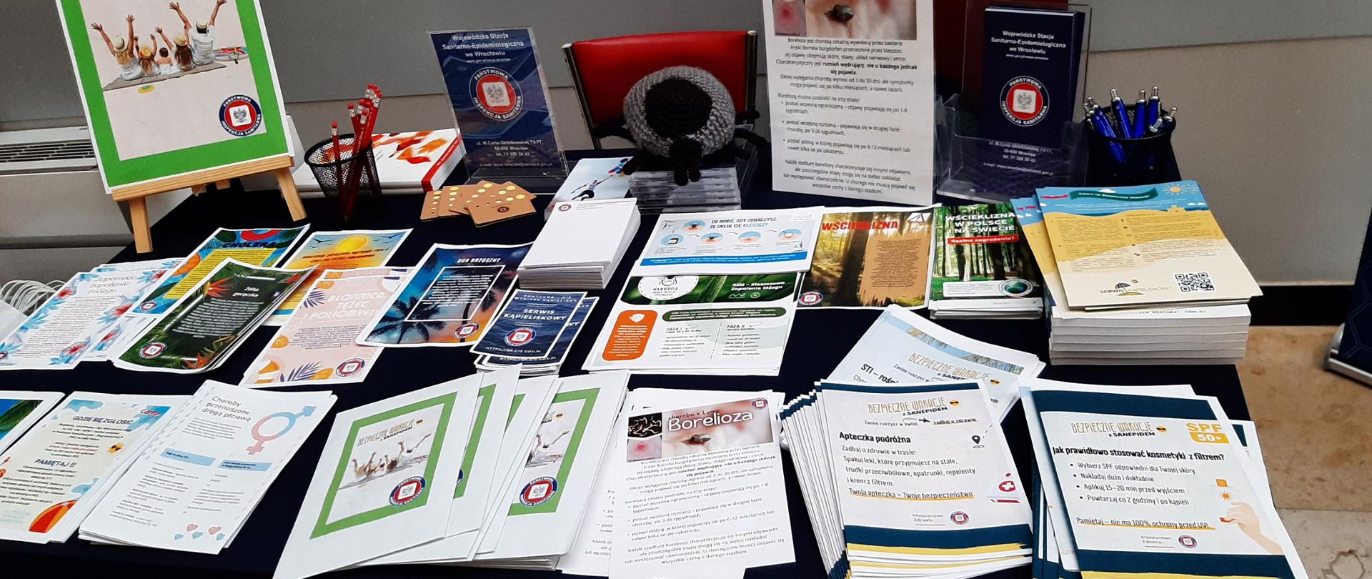 Punkt konsultacyjny z rozłożonymi na nim ulotkami