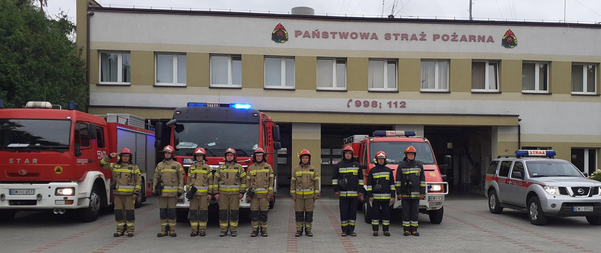 Zdjęcie przedstawia zmianę służbową JRG Wieluń przed budynkiem KP PSP Wieluń, wraz z wyprowadzonymi samochodami bojowymi podczas uczczenia rocznicy wybuchu Powstania Warszawskiego